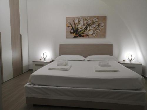 a bedroom with a large white bed with two night stands at Casa Nannina in Matera