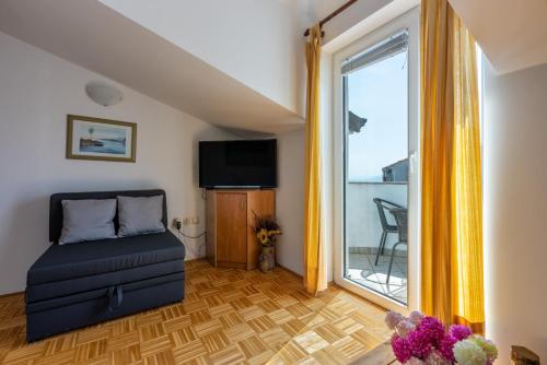 a living room with a couch and a window at Apartments Villa Bare in Kastav