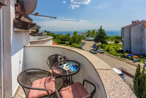 a balcony with a table and chairs and a street at Apartments Villa Bare in Kastav