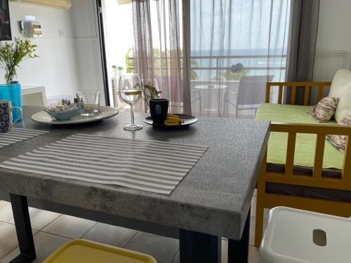 a dining room table with a glass of wine on it at Krasas Beach in Larnaka
