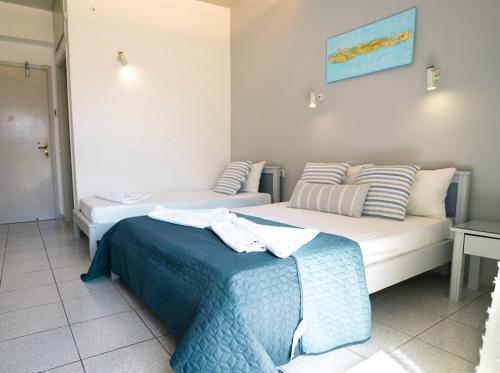 a hotel room with two beds and a table at RODI BLUE appartments in Amoudara Herakliou