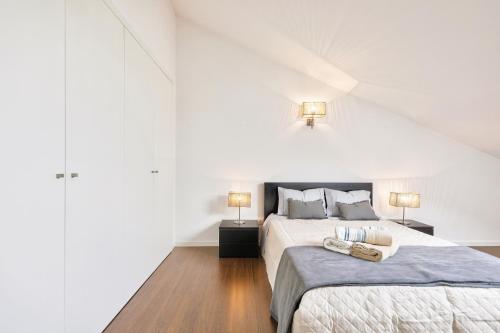 1 dormitorio blanco con 2 camas y 2 lámparas en Sea & River Vagueira Apartment by Home Sweet Home Aveiro en Praia da Vagueira