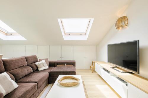 a living room with a couch and a flat screen tv at Sea & River Vagueira Apartment by Home Sweet Home Aveiro in Praia da Vagueira