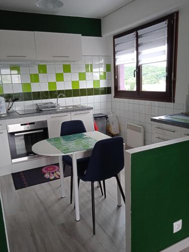 a kitchen with a table and chairs in it at Les tilleuls in Vittel