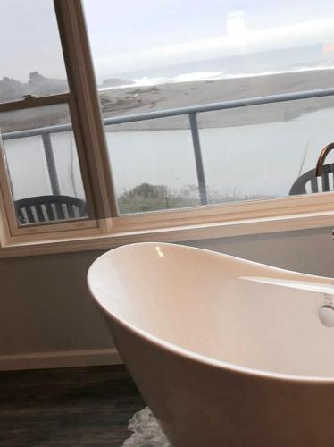 a white bath tub in front of a window at Hotel Breakers in Gualala