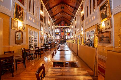 a restaurant with wooden tables and chairs in a room at Amsterdam Castle NY in Amsterdam