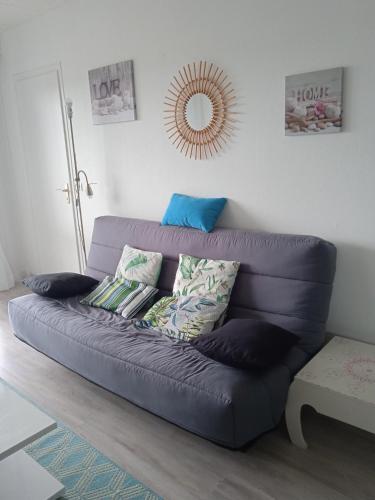 a blue couch in a living room with a mirror at Les tilleuls in Vittel