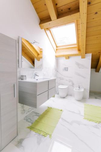a white bathroom with two sinks and a window at CASA KING 2 in Como