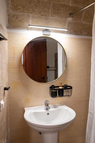 a bathroom with a sink and a mirror at Kyklamino Castlehouse in Monemvasia