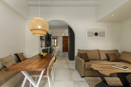 sala de estar con mesa y sofá en Kamares Boutique Residence, en Rethymno