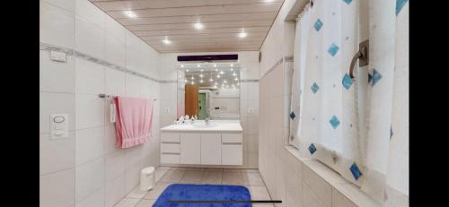a white bathroom with a sink and a mirror at Chalet Finkenwiese in Zweisimmen
