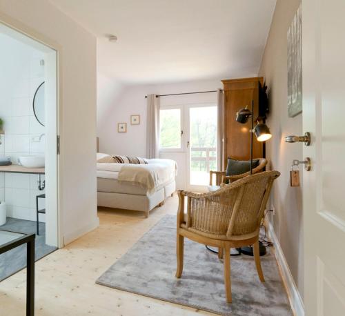um quarto com uma cama, uma cadeira e uma mesa em Haus Nagel em Hinterzarten