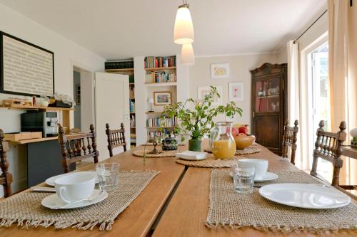 una mesa de comedor con platos y tazas. en Haus Nagel, en Hinterzarten