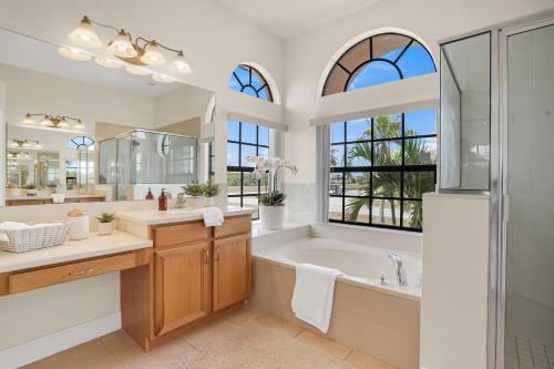 a bathroom with a tub and a sink and a mirror at Luxury Villa in Punta Gorda Isles in Punta Gorda