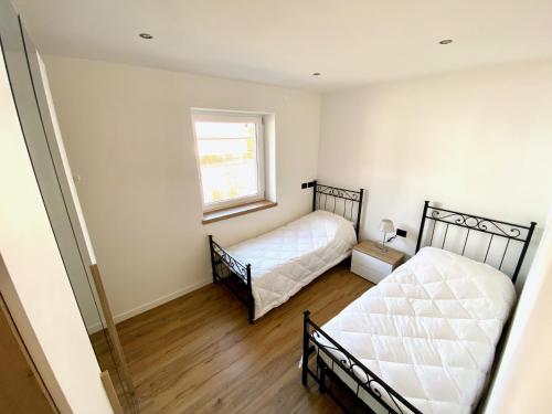 a bedroom with two beds and a window at Villa Dada in Predazzo