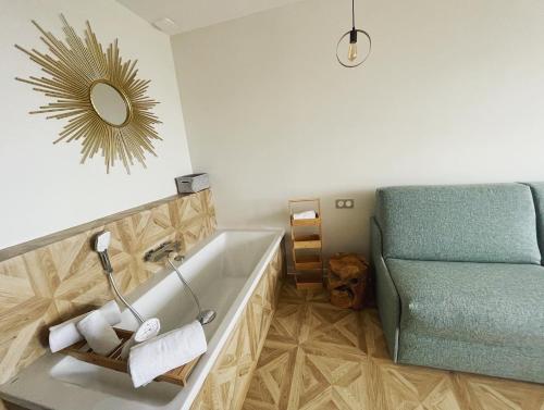 a bathroom with a tub and a chair and a dog at Hôtel La Grande Conque in Cap d'Agde