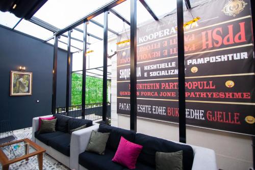 a room with two couches and a large wall of signs at Boutique Hotel Kooperativa in Pogradec