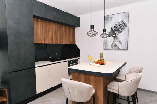 a kitchen with white cabinets and a island with chairs at Luxury Apartment Maria Solare in Opatija
