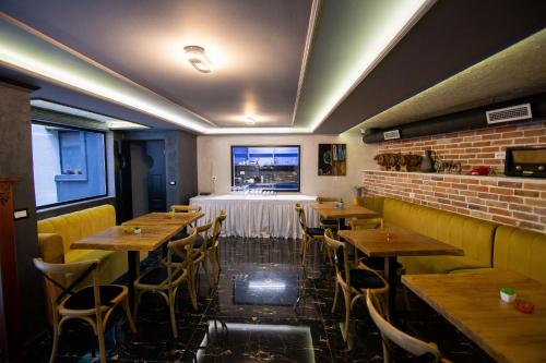 a restaurant with wooden tables and chairs and a window at Boutique Hotel Kooperativa in Pogradec