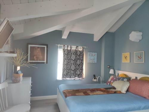 a bedroom with a bed with blue walls and a window at Ca' Moni - Imola in Imola