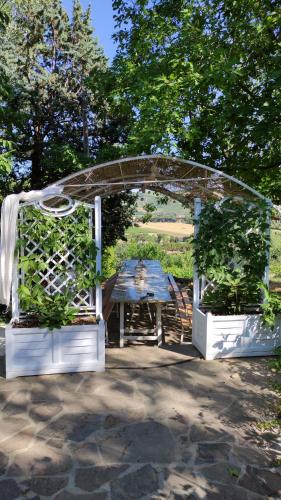 a picnic table under an arch in a garden at Ca' Moni - Imola in Imola