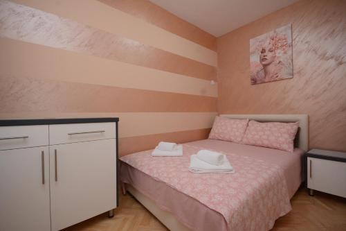 ein kleines Schlafzimmer mit einem Bett und einer Kommode in der Unterkunft Apartman Jocić in Vrnjačka Banja