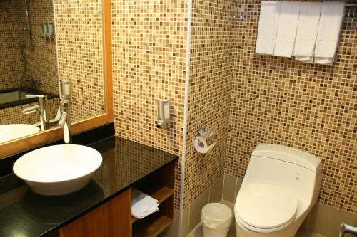 a bathroom with a white toilet and a sink at Fullon Resort Kending in Eluan
