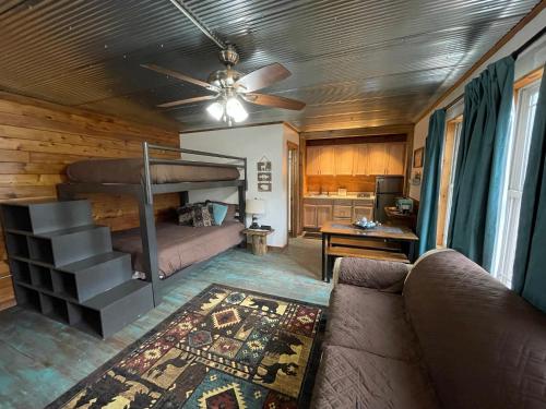 ein Wohnzimmer mit einem Sofa und einem Etagenbett in der Unterkunft Country Cottage at Camp Creek Cabins in Spanishburg