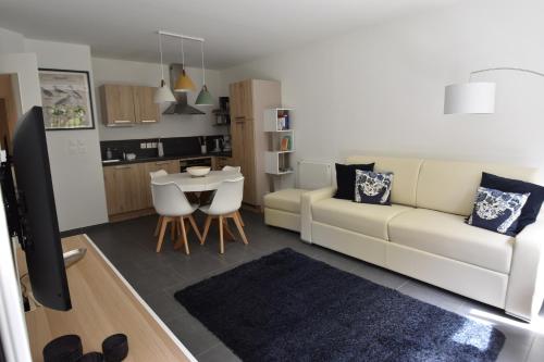 un salon avec un canapé blanc et une table dans l'établissement Le Temps d'une Escale à St Wary, à Saint-Valery-sur-Somme