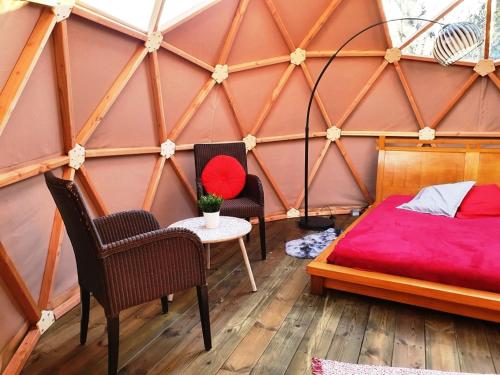 a room with a bed and chairs in a yurt at bulle d'amour à 500 m de la plage in Cancale