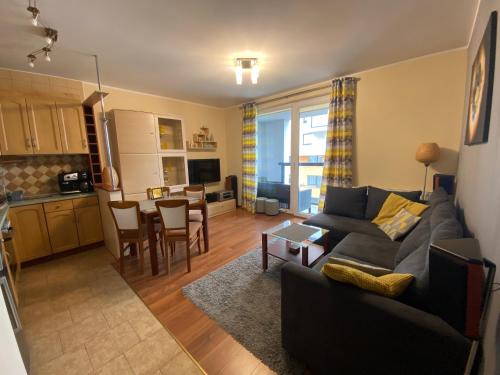 un soggiorno con divano e tavolo e una cucina di Ann Apartament Horyzont a Danzica