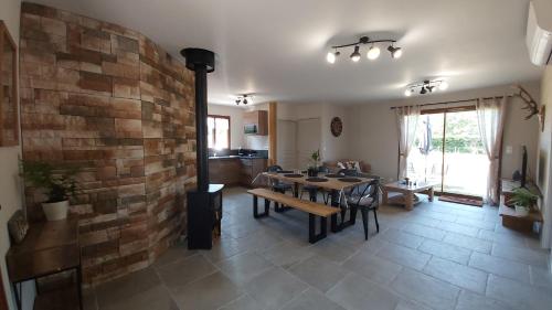 une salle à manger avec une table et un mur de briques dans l'établissement Gîte Le Cerf Solognot proche château Chambord, Lamotte Beuvron, à Neung-sur-Beuvron