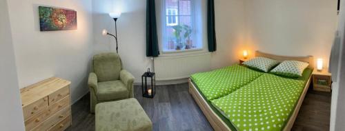 a bedroom with a green bed and a chair at SWEET HOME in Krásná Lípa