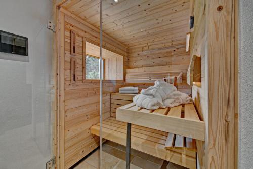 uma sauna com paredes de madeira e uma parede de vidro em Eibele Chalets em Oberstaufen