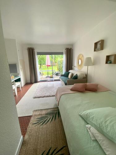 a bedroom with two beds and a living room at Cottage au sein du "Hameau du golf" de la Bretesche in Missillac