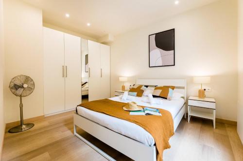 een slaapkamer met een groot bed en een ventilator bij BARTOLOME Suite Apartment in San Sebastian