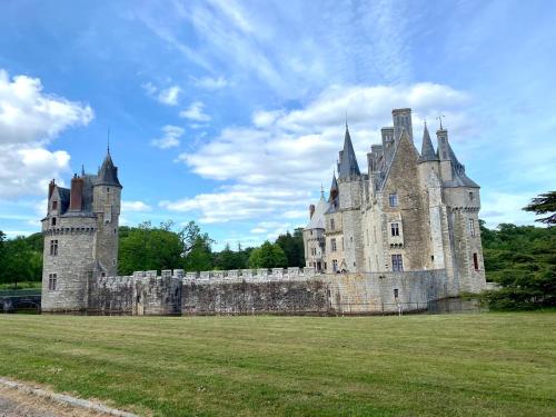 Cottage au sein du "Hameau du golf" de la Bretesche في Missillac: قلعة قديمة تقع على أرض عشبية