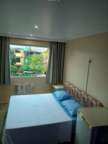 a bedroom with a bed and a window at Hostel Paraíso in Arraial do Cabo