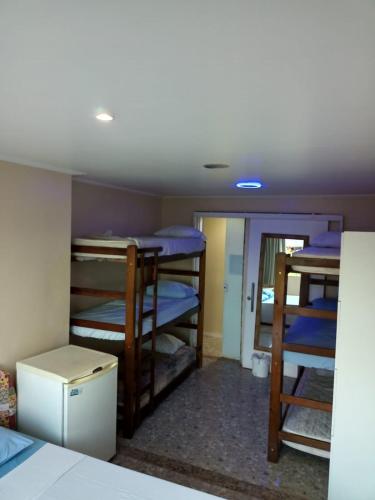 a dorm room with several bunk beds in it at Hostel Paraíso in Arraial do Cabo