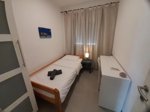 a small bedroom with two beds and a window at Apartman Vitamare 160 m from the beach in Novi Vinodolski