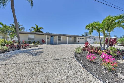 a house with palm trees and flowers in the driveway at Waterfront Bradenton Home Heated Pool and Fire Pit in Bradenton