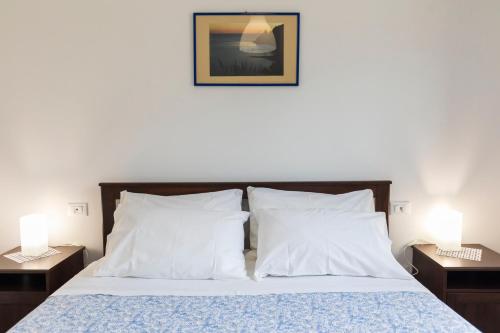 a bedroom with a bed with two nightstands and two lamps at Villa Alice in Capo Vaticano