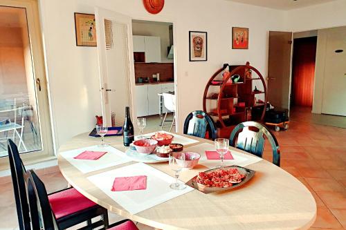 une table avec une assiette de nourriture et des verres à vin dans l'établissement Charmant 110m avec BALCON au CENTRE vieille-ville, à Annecy