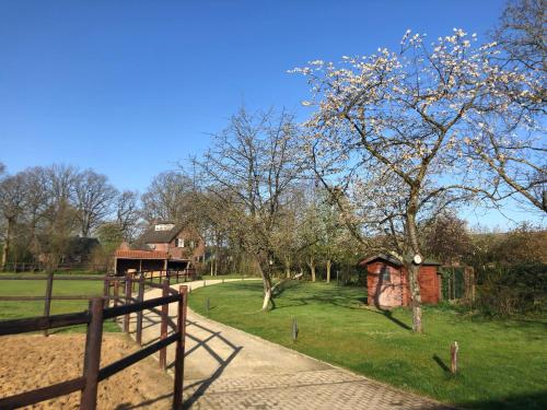 a park with a fence and a tree and a playground at Horse and Hound in Riethoven