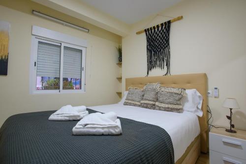 1 dormitorio con 1 cama con toallas en Almansa Malaga Center, en Málaga