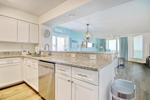 a kitchen with white cabinets and a counter top at East End Escape in Myrtle Beach