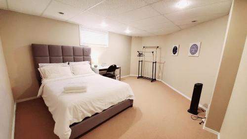 a bedroom with a large bed and a desk at Saskatoon Lashyn Cove Homestay in Saskatoon