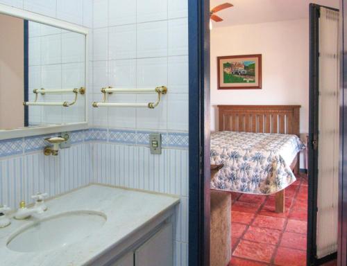 een badkamer met een wastafel, een spiegel en een bed bij Casa de campo c Churrasq e Piscina, Porto Feliz SP in Pôrto Feliz