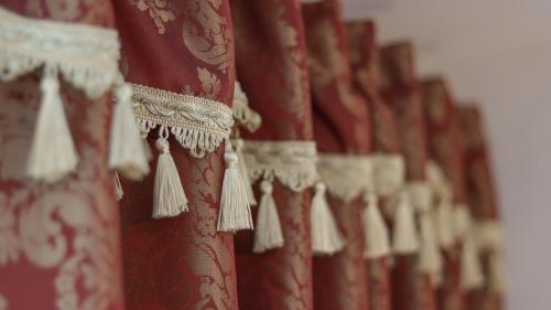 a row of red curtains with white tassels at Wrzos & Belvedere in Kudowa-Zdrój