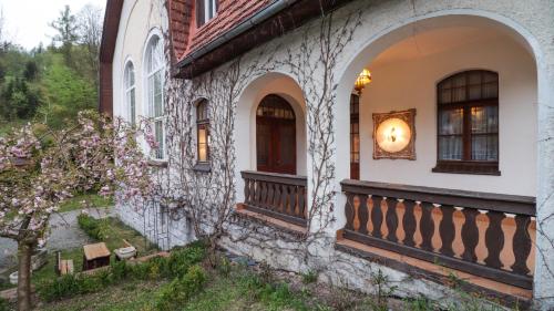ein Steinhaus mit einer Veranda und einem Balkon in der Unterkunft Wrzos & Belvedere in Kudowa-Zdrój
